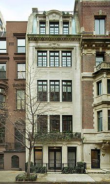 an apartment building with many windows and balconies on the top floor, next to a tree