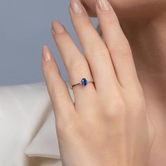 a woman's hand with a blue ring on it