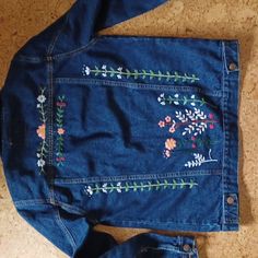 a pair of jeans with embroidered flowers on them