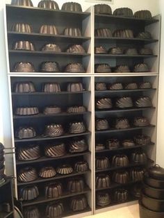 a room filled with lots of metal pots and pans on shelves next to each other