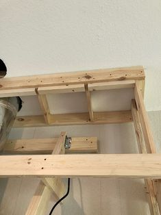 a wooden shelf with some tools on top of it and a black object in the background