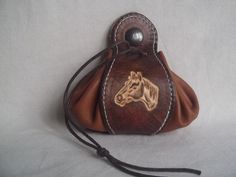 a brown purse with a horse head on it's side and a string around the bottom