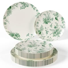 three plates sitting on top of each other in front of a white background with green flowers