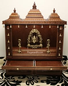 an ornate wooden shrine with gold decorations on the front and sides, sitting on a black and white rug