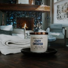 a can of cozy sweater sits on a plate in front of a fireplace