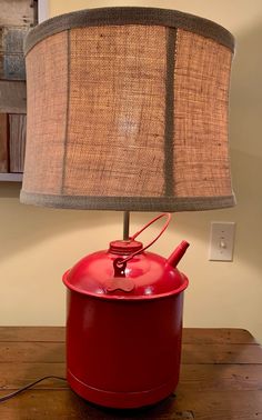 a red pot with a lamp on top of it