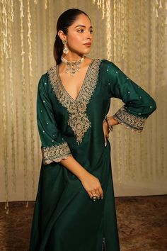 Emerald green long kaftan with placed thread embroidered paisley motifs embellished by sequins. Comes with matching doghri salwar.
Components: 2
Pattern: Embroidered
Type Of Work: Thread, Sequin
Neckline: V-neck
Sleeve Type: Three quarter
Fabric: Silk Dupion
Color: Emerald Green
Other Details: 
Flared silhouette
Occasion: Sangeet,Mehendi and Haldi - Aza Fashions Salwar Women, Long Kaftan, Green Silk, Indian Wear, Aza Fashion, Three Quarter, Emerald Green, Types Of Sleeves, Paisley