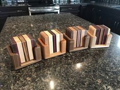 four pieces of wood sitting on top of a granite countertop next to each other