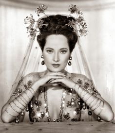 an old black and white photo of a woman wearing a veil