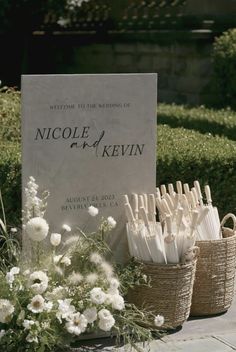 the welcome sign for nicole and kevin is surrounded by baskets with umbrellas in them