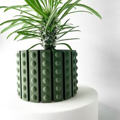 a green potted plant sitting on top of a white cake covered in legos