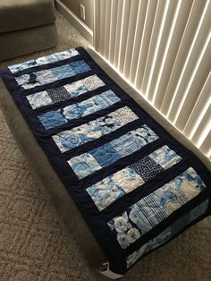 a blue and white quilt on the floor