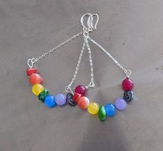 Fast First Class Shipping. Ships in 2-3 days You will love these bright rainbow Multi Jade gemstone earrings. They are perfect for June gay pride month. Or for opening and activating all of your chakras. They have a fun, carefree and elegant style. You will get noticed with a lot of compliments with these cute earrings. The different colored jasper is good for opening the chakras and bringing restored and positive energy. Rainbow Earrings Features: Coral, Jasper, Yellow Jade, Machite, Blue Jade, Rainbow Round Bead Earrings For Pierced Ears, Rainbow Round Beads Jewelry With Ear Wire, Rainbow Dangle Earrings With Ear Wire, Rainbow Dangle Hoop Earrings With Ear Wire, Rainbow Handmade Beaded Dangle Earrings, Pride Jewelry Diy, Handmade Rainbow Dangle Earrings, Unique Handmade Rainbow Earrings, Rainbow Beaded Dangle Hoop Earrings