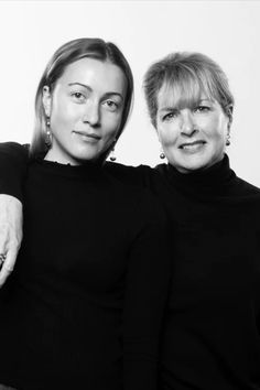 two women standing next to each other in black and white