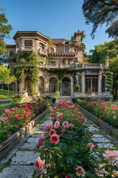 a large house with lots of flowers in front of it