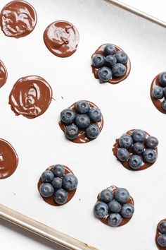 blueberries and chocolate on a baking sheet ready to go into the oven with melted chocolate