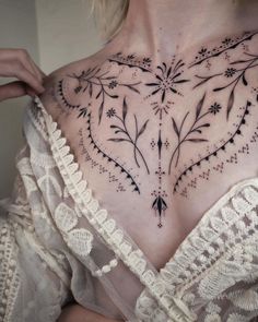 a woman with tattoos on her chest