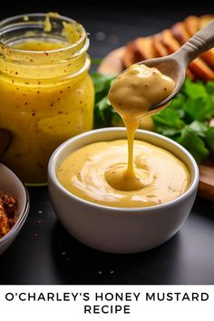 a spoon full of honey mustard being drizzled into a bowl