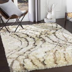 a white rug with brown swirls on it in a living room next to a chair