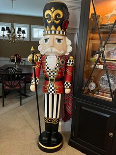 a large nutcracker standing next to a display case in a room with furniture