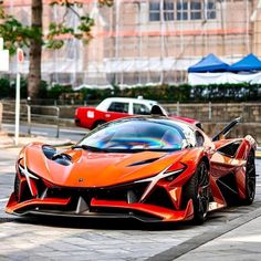 an orange sports car is parked on the street