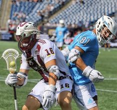 two lacrosse players are playing on the field