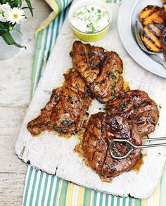 grilled meat on a cutting board with other food items