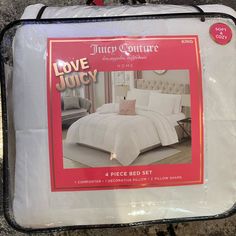 a white bed set with pink accents on the cover