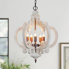 a chandelier hanging from the ceiling in a room with white walls and windows