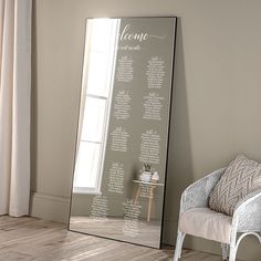 a large mirror sitting on top of a wooden floor next to a chair and window