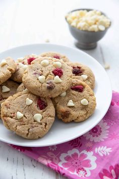 a white plate topped with cookies covered in nuts