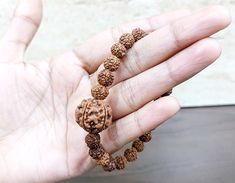 Rudraksha Face - 5 Face (Mukhi) Material - Natural Bads Small Beads Size -  5 mm to  6 mm Big Beads Size -  13 mm To 15 mm Color - Brown Size - Stretchable 5 Mukhi Rudraksha Represents Lord "Rudra Kalagni" Which Symbolizes The 5 Forms Of Lord Shiva. This Auspicious Rudaksha Helps Awaken One's Higher Self Means "upa guru" And Through That To god.  Hence It Is The Most Widely Worn Bead By Students And Sages Since Ancient Times.  The Planet Associated With 5 Mukhi Rudraksha Is Jupiter. Hence, 5 Muk Hand-strung Beaded Bracelets For Puja, Lord Rudra, 5 Mukhi Rudraksha, Rudraksha Bracelet, Small Beads, Higher Self, Prayer Beads, Ancient Times, Lord Shiva