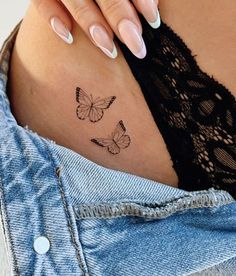 a woman's stomach with two butterflies on her belly and the word love written in black ink