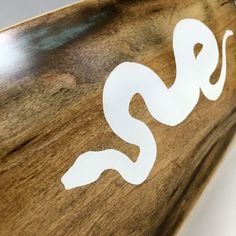 a close up of a wooden sign with the word snake on it's side