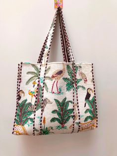 a handbag hanging on the wall with an animal and palm tree pattern in it