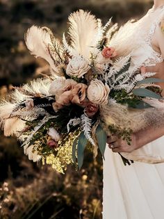 a bridal holding a bouquet of flowers and feathers