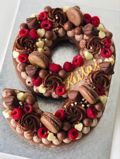 a chocolate cake decorated with raspberries and nuts