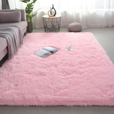 a living room with a pink rug on the floor and a couch in the background