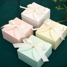 three different colored boxes with bows on them