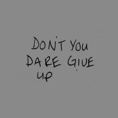 the words don't you dare give up written in black ink on a gray background