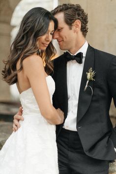 a man in a tuxedo standing next to a woman