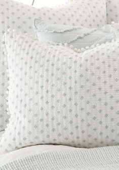 a close up of a bed with white pillows