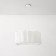 a white lamp hanging from the ceiling in a room with no one around it,