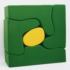 a green and yellow abstract piece on a white background