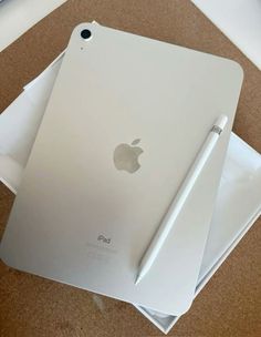 an apple ipad with a pen on top of it