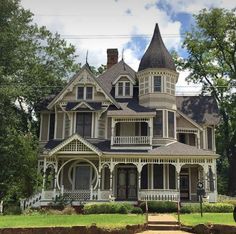 an old victorian style house with white trim