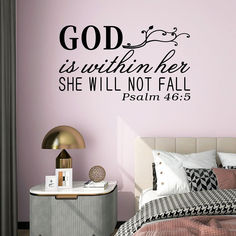 a bedroom with a bed, nightstand and wall decal that says god is within her she will not fall