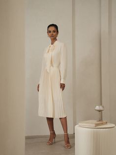 Cream A-line Midi Dress For Work, Elegant Knee-length Pleated Skirt For Party, Chic Dress With Pleated Back For Work, Chic Pleated Back Dress For Work, Elegant Midi Dress With Pleated Back, Elegant Pleated Back Midi Dress For Work, Chic A-line Midi Dress With Pleated Skirt, Feminine Fitted Knee-length Pleated Dress, Feminine Knee-length Fitted Pleated Dress