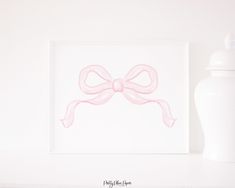 a pink bow sitting on top of a white shelf next to a bottle and vase