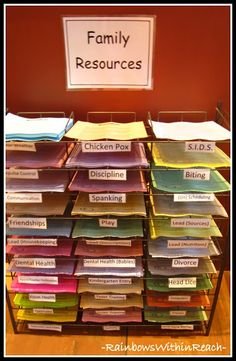 a large stack of files sitting on top of a wooden table next to a sign